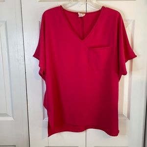 Women’s short sleeve top. Fusion pink with front pocket.